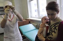 A medical worker prepares to administer a vaccine to 16 month old Yaroslav who is being held my his mother Oksana in Ukraine, 2009.