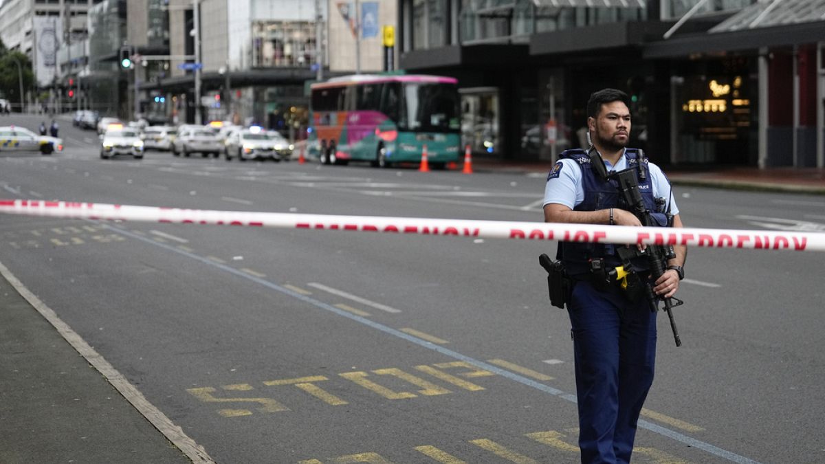 An armed New Zealand police officer stands at a road block in the central business district following a shooting in Auckland, New Zealand, Thursday, July 20, 2023.
