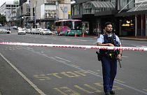 Silahlı bir Yeni Zelanda polisi, 20 Temmuz 2023 Perşembe günü Yeni Zelanda'nın Auckland kentinde meydana gelen bir silahlı saldırının ardından merkezi iş bölgesindeki bir yol barikatında duruyor.