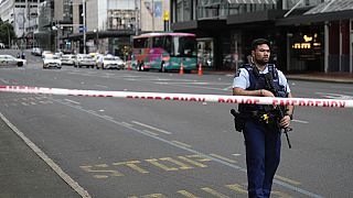 An armed New Zealand police officer stands at a road block in the central business district following a shooting in Auckland, New Zealand, Thursday, July 20, 2023.