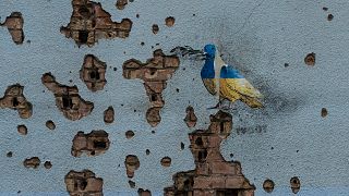 A arte de TvBoy numa parede atingida por estilhaços russos em Ispin, Ucrânia