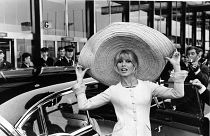 French actress Brigitte Bardot poses with a huge sombrero she brought back from Mexico, as she arrives at Orly Airport in Paris, France, on May 27, 1965.