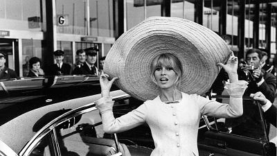 French actress Brigitte Bardot poses with a huge sombrero she brought back from Mexico, as she arrives at Orly Airport in Paris, France, on May 27, 1965.