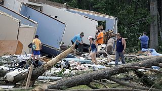 People survey the damage to their home that was destroyed by a tornado on Wednesday, July 19, 2023, in Dortches, NC.