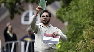 Salwan Momika, behind Sunday's protest, holds up the Muslim holy book the flag of Iraq during a protest outside the Iraqi Embassy in Stockholm, Sweden, in July