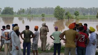 مزارعون ينظرون إلى محاصيلهم غارقة في مياه الفيضانات في قرية غونيوالا في ولاية البنجاب الهندية في 20 يوليو 2023.