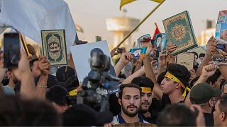 Iraqis raise copies of the Quran during a protest in Tahrir Square on in Baghdad, Iraq. It was in response to the burning of Quran in Sweden.