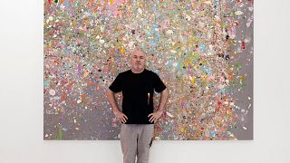 Damien Hirst in front of one of his new paintings