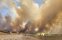 Clouds of smoke from a forest fire rise to the sky on the island of Rhodes, Greece, Saturday, July 22, 2023.