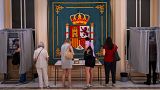 People pick their ballots before voting at a polling station for Spain's general election, in Madrid, Sunday, July 23, 2023