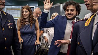 Patrick Zaki waves upon his arrival at the Milan Malpensa airport, Italy, Sunday, July 23, 2023. 