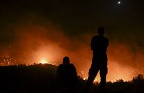People watch the fires near the village of Malona in the Greek island of Rhodes on July 23, 2023.