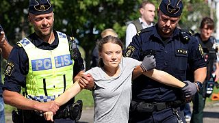 Климатическую активистку Грету Тунберг уводят полицейские с климатической акции в Ольехамнене в Мальмё, Швеция, 24 июля 2023 года