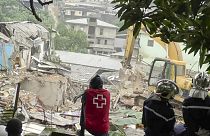 Helfer in Douala starren fassungslos auf die Trümmerwüste am 24. Juli 2023