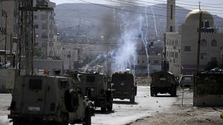 القوات الإسرائيلية تطلغ الغاز المسيل للدموع باتجاه متظاهرين فلسطينيين في مخيم عسكر للاجئين في مدينة نابلس بالضفة الغربية 24/07/2023