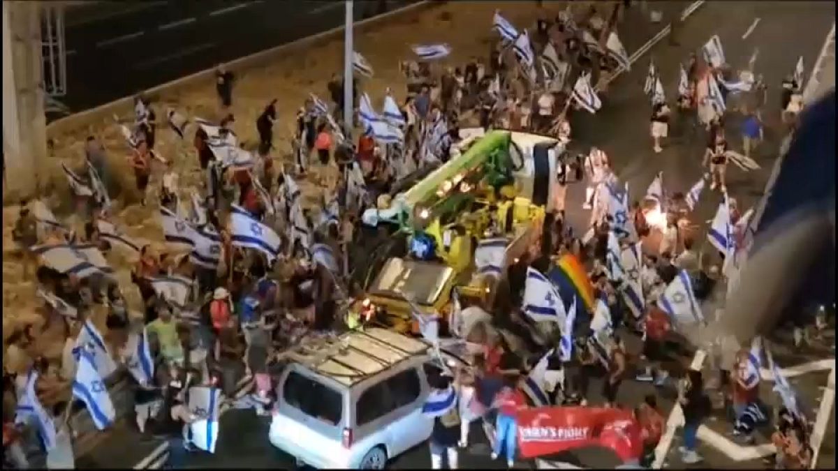 A silver van drives at protesters in Tel Aviv