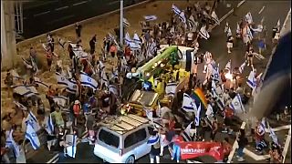 A silver van drives at protesters in Tel Aviv