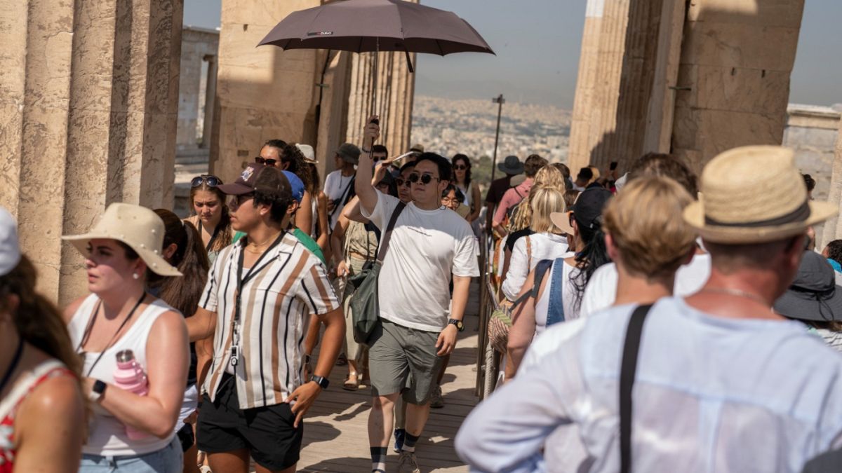 دخول السياح إلى تل الأكروبوليس القديم خلال موجة حر ، في أثينا ، اليونان، 13 يوليو 2023.