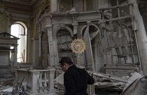 A church personnel salvages items while helping clean up inside the Odesa Transfiguration Cathedral after it was heavily damaged in Russian missile attacks in Odesa, Ukraine