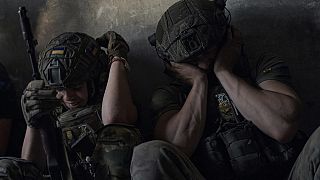 Soldados ucranianos se cubren los oídos para protegerse de los bombardeos de los tanques rusos en un refugio en la región de Zaporiyia, Ucrania, el 2 de julio de 2023