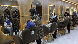 FILE- Beauticians put makeup on customers at Ms. Sadat's Beauty Salon in Kabul, Afghanistan, Sunday, April 25, 2021.