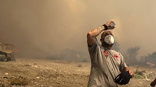 Homem ajuda a combater os fogos na ilha de Rodes, Grécia