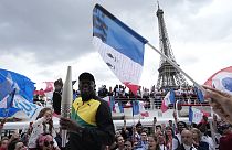Usain Bolt, antigo atleta jamaicano, segura a tocha olímpica na terça-feira, 25 de julho de 2023, em Paris, França