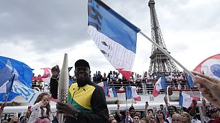 Usain Bolt, antigo atleta jamaicano, segura a tocha olímpica na terça-feira, 25 de julho de 2023, em Paris, França