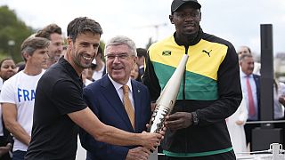 IOC-Präsident Thomas Bach an der Seite von Usain Bolt in Paris am 25. Juli 2023