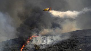 Un avión Canadair deja caer agua sobre un incendio forestal en el pueblo de Vati, en la isla de Rodas, en el mar Egeo, al sureste de Grecia, el martes 25 de julio de 2023\.