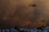Um helicóptero sobrevoa um incêndio florestal na aldeia de Gennadi, na ilha de Rodes, no Mar Egeu, a 25 de julho de 2023.