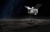 Image shows a rendering of the Origins Spectral Interpretation Resource Identification Security - Regolith Explorer (OSIRIS-REx) spacecraft contacting the asteroid Bennu.