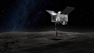 magem mostra uma representação da sonda espacial OSIRIS-REx em contato com o asteroide Bennu