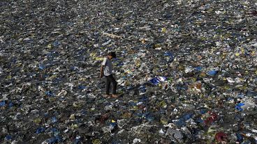 A boy walks on the plastic waste at the Badhwar Park beach on the Arabian Sea coast in Mumbai, India,