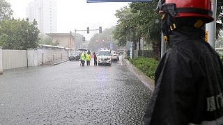 Firefighter surveills a cordonened off area under heavy rainfall during Typhoon Doksuri 