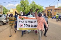 "Нам не нужен государственный переворот": в Нигере проходят демонстрации как противников свергнутого президента, так и его сторонников (на фото с транспарантом)