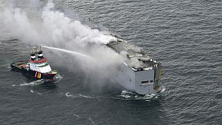 A boat hoses the smoke from a fire which broke out on a freight ship in the North Sea, about 27 kilometers (17 miles) north of the Dutch island of Ameland, Wednesday, July 26.