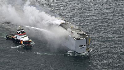 A boat hoses the smoke from a fire which broke out on a freight ship in the North Sea, about 27 kilometers (17 miles) north of the Dutch island of Ameland, Wednesday, July 26.