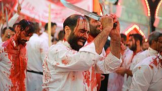 Irakische Schiiten geißeln sich selbst und schlagen sich die Köpfe mit Schwertern während einer Aschura-Prozession in der Stadt Kerbala