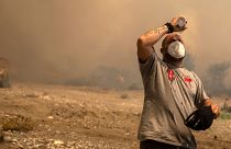 A volunteer cools himself during a wildfire in Vati village, on the Aegean Sea island of Rhodes, southeastern Greece.