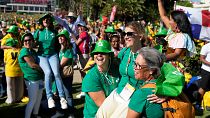 Des volontaires sont soutenus par d'autres après une messe célébrée pour les volontaires du monde entier à Estoril, près de Lisbonne, le mercredi 26 juillet 2023.