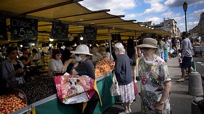 People shop at a market in Versailles, outside Paris, France