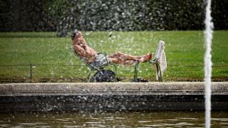 رجل يستريح في حديقة في باريس بعد ارتفاع درجات الحرارة غلى مستويات قياسية 