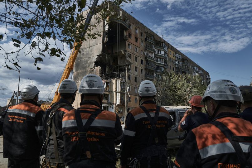 Emergency services work at a scene after a missile hit an apartment building in Kryvyi Rih, July 2023