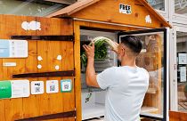 William, employee at association Eco-Citoyen, refills a public refrigerator where people can give and take food, in Geneva, Switzerland, 28 July 2023.