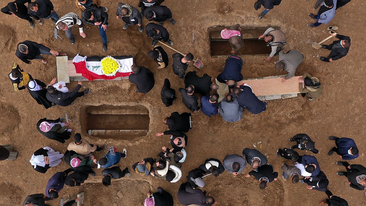 صورة من الجو لمشيعين يستعدون لدفن رفات ضحايا ايزيديين في مقبرة سنجار بالعراق.