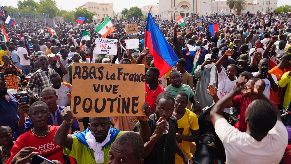 مردم نیجر در راهپیمایی در حمایت از کودتاچیان در روز یکشنبه ۳۰ ژوئیه. روی پلاکارد نوشته شده است: «مرگ بر فرانسه، زنده باد پوتین».