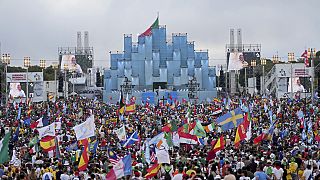 Several tens of thousands of pilgrims attend the opening mass of World Youth Day, celebrated by Lisbon Cardinal Manuel Clemente, on the video screens.
