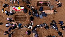 نمایی هوایی از عزاداران در حال دفن اجساد قربانیان ایزدی کشته شده توسط داعش در قبرستانی در سنجار، عراق، ۲۰۲۱