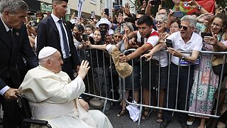 Pope Francis waves to the crowd as he arrives for a meeting with the Portugal's Prime Minister Antonio Costa in Lisbon.
